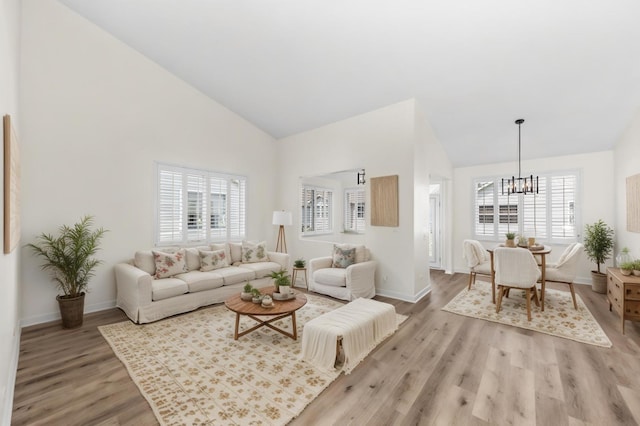 1468 W Grand Haven Rd, Romeoville, IL 60446 - living room with high vaulted ceiling, a chandelier, light wood-style flooring, and baseboards