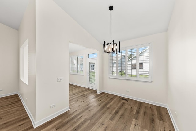 1468 W Grand Haven Rd, Romeoville, IL 60446 - unfurnished dining area featuring a chandelier, wood finished floors, baseboards, and high vaulted ceiling