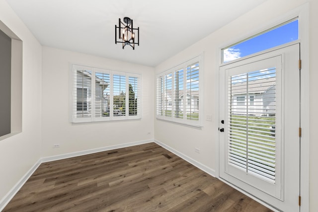 1468 W Grand Haven Rd, Romeoville, IL 60446 - unfurnished dining area featuring dark wood finished floors, a chandelier, and baseboards