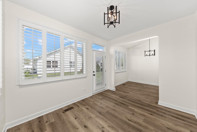 1468 W Grand Haven Rd, Romeoville, IL 60446 - unfurnished dining area with a chandelier, wood finished floors, and baseboards