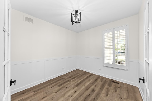 1468 W Grand Haven Rd, Romeoville, IL 60446 - unfurnished dining area with a chandelier, wood finished floors, and wainscoting