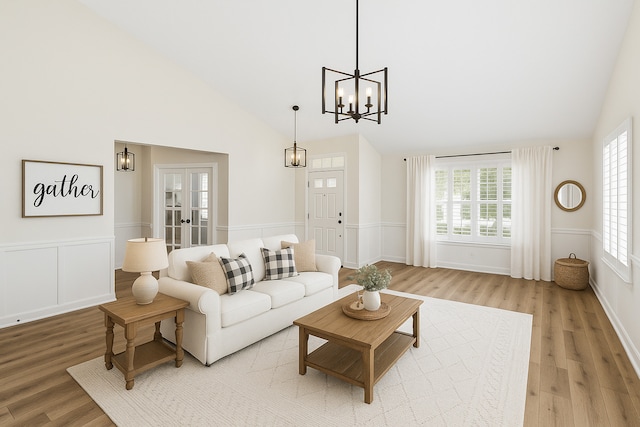 1468 W Grand Haven Rd, Romeoville, IL 60446 - living area with light wood-type flooring, a chandelier, high vaulted ceiling, french doors, and a wainscoted wall
