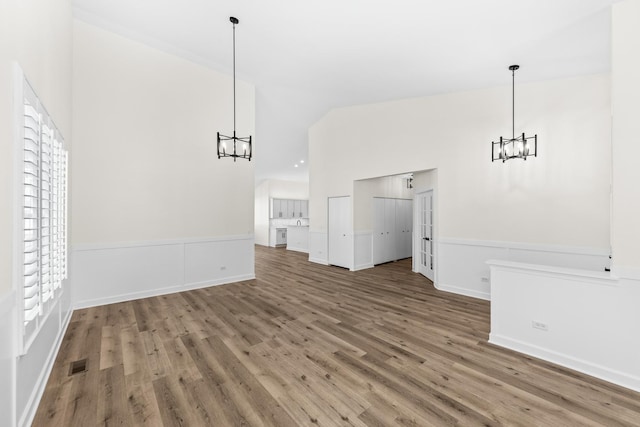 1468 W Grand Haven Rd, Romeoville, IL 60446 - unfurnished dining area featuring a chandelier, wood finished floors, high vaulted ceiling, and baseboards