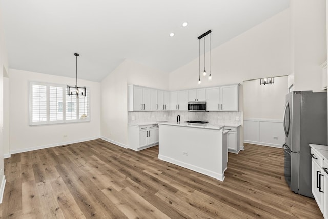 1468 W Grand Haven Rd, Romeoville, IL 60446 - kitchen with appliances with stainless steel finishes, high vaulted ceiling, light countertops, decorative backsplash, and a chandelier