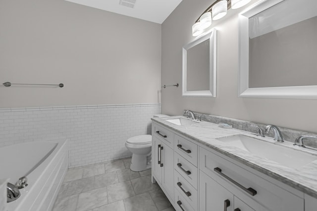 10 Millbrook Ct, Algonquin, IL 60102 - full bathroom featuring double vanity, a wainscoted wall, a bath, tile walls, and toilet