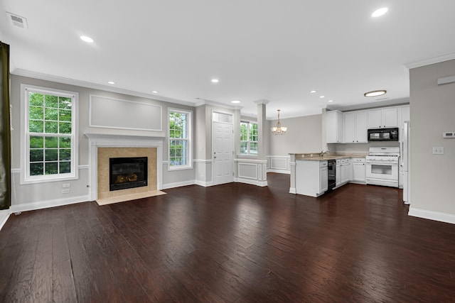 10 Millbrook Ct, Algonquin, IL 60102 - unfurnished living room featuring crown molding, a tiled fireplace, dark wood-style flooring, a chandelier, and baseboards
