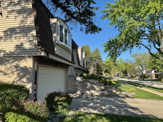 view of side of property with brick siding and a garage