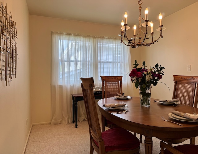 carpeted dining room featuring a chandelier and baseboards
