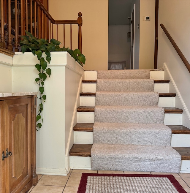 staircase featuring tile patterned flooring