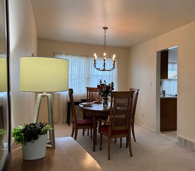 dining room with a chandelier, carpet flooring, and baseboards