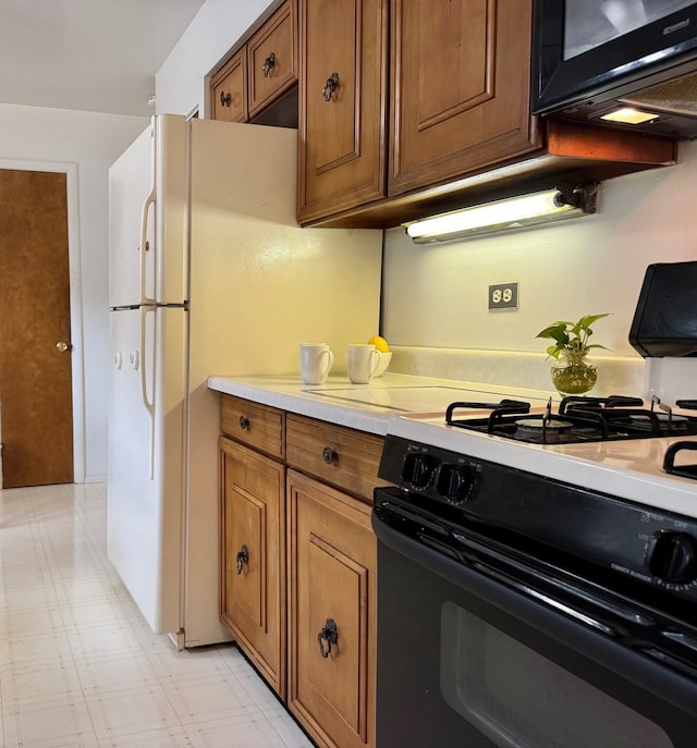 kitchen featuring black appliances, brown cabinetry, light countertops, and light flooring