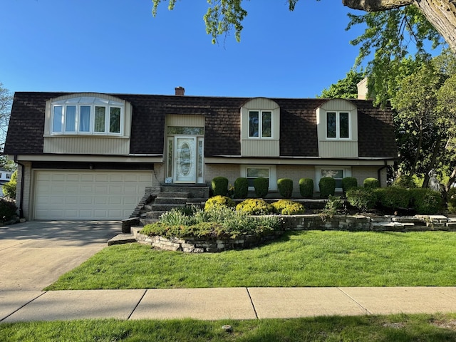 split foyer home with mansard roof, a shingled roof, a front lawn, and concrete driveway