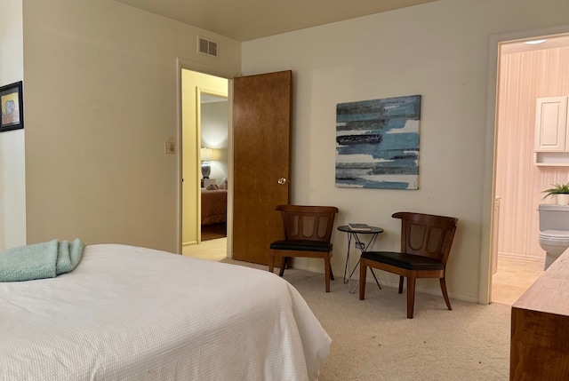 bedroom with light carpet and ensuite bathroom