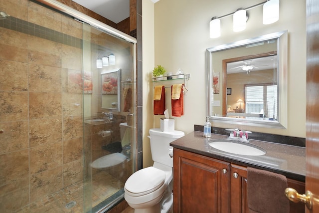 full bath featuring toilet, a shower stall, vanity, and a ceiling fan