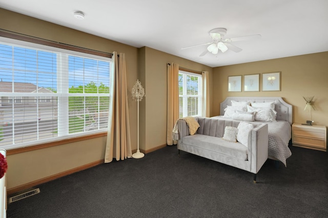 bedroom featuring dark colored carpet, baseboards, and a ceiling fan