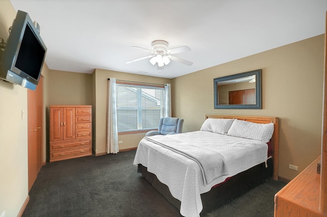 bedroom with baseboards, dark carpet, and a ceiling fan