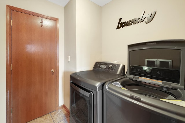 laundry room with separate washer and dryer and light tile patterned floors
