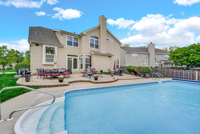 view of swimming pool with a patio area and fence