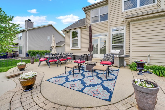 view of patio / terrace with grilling area, outdoor dining space, and fence