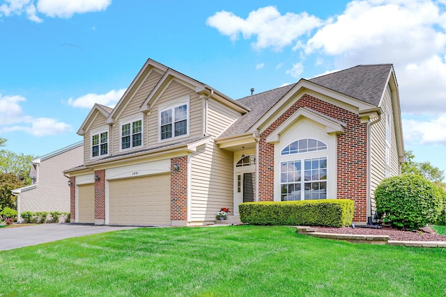 view of front facade with a garage, brick siding, a front yard, driveway, and a shingled roof