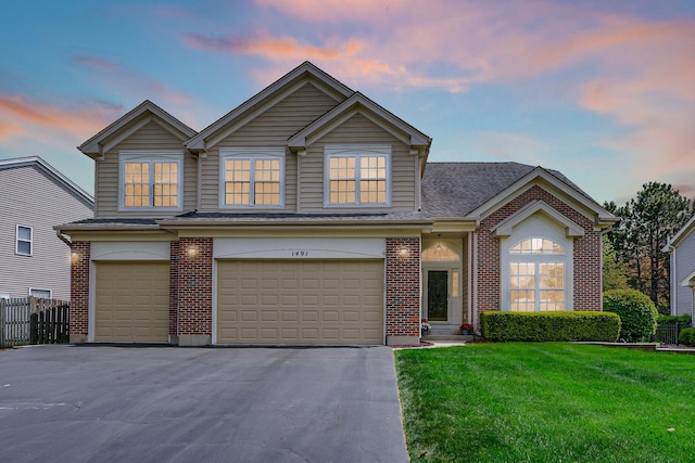 traditional-style home featuring a garage, brick siding, driveway, and a shingled roof