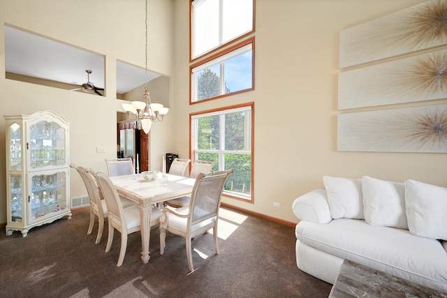 dining room with dark colored carpet, a chandelier, baseboards, and a high ceiling