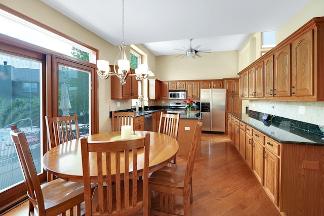dining room with light wood-style floors, a ceiling fan, and a chandelier