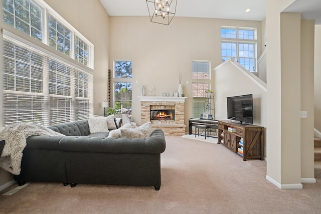 718 Northgate Dr, Sycamore, IL 60178 - carpeted living area featuring a towering ceiling, baseboards, stairway, a chandelier, and a glass covered fireplace