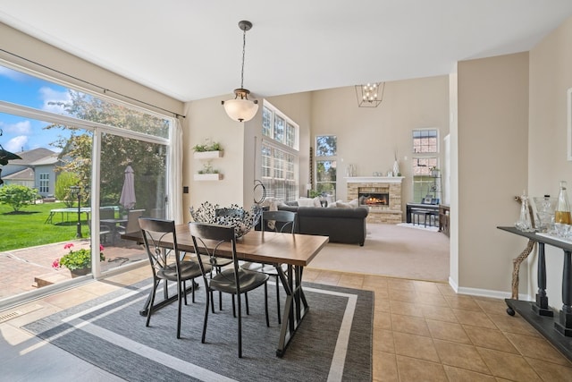 718 Northgate Dr, Sycamore, IL 60178 - tiled dining area featuring baseboards, a fireplace, and a chandelier
