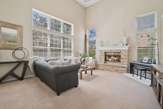 718 Northgate Dr, Sycamore, IL 60178 - carpeted living area featuring a towering ceiling, a fireplace, and baseboards