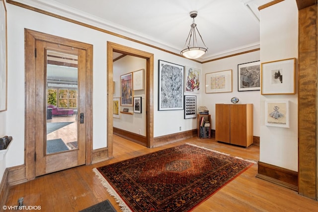 entrance foyer featuring hardwood / wood-style flooring, baseboards, and ornamental molding