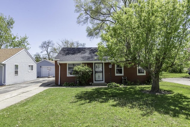 1705 Lyons Ct, Waukegan, IL 60085 - view of front facade featuring driveway, an outbuilding, a front lawn, a garage, and a shingled roof