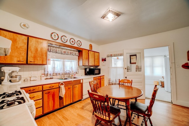 218 W Fleming St, Watseka, IL 60970 - kitchen featuring a sink, white appliances, brown cabinetry, tasteful backsplash, and light countertops