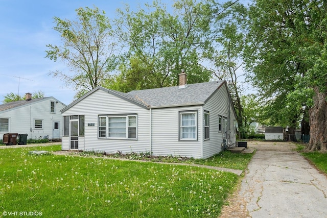 6609 173rd Pl, Tinley Park, IL 60477 - view of front of property with concrete driveway, a chimney, a front yard, and a shingled roof