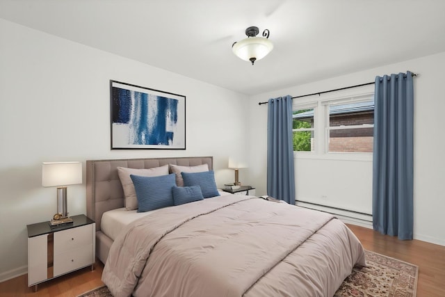 6436 W 64th Pl Unit A3, Chicago, IL 60638 - bedroom featuring a baseboard heating unit, wood finished floors, and baseboards