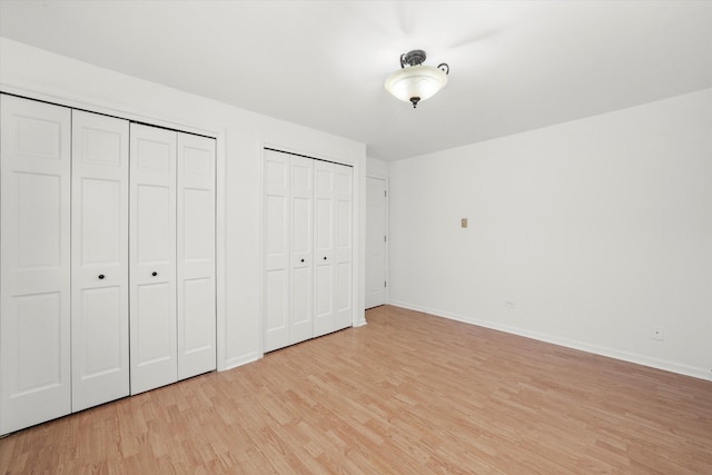 6436 W 64th Pl Unit A3, Chicago, IL 60638 - unfurnished bedroom featuring multiple closets, light wood-style flooring, and baseboards