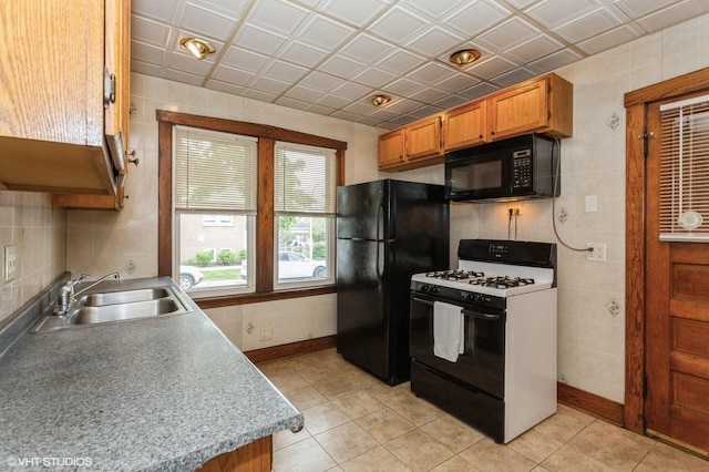 5000 N Kenneth Ave, Chicago, IL 60630 - kitchen featuring black appliances, a sink, light tile patterned floors, and brown cabinetry