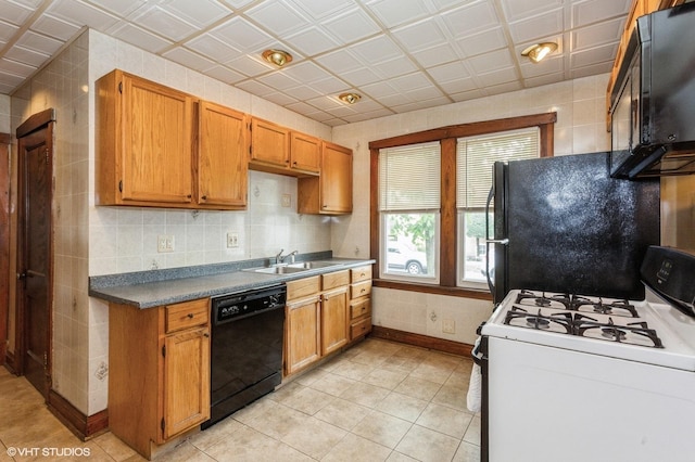 5000 N Kenneth Ave, Chicago, IL 60630 - kitchen featuring black appliances, a sink, light tile patterned floors, baseboards, and brown cabinetry