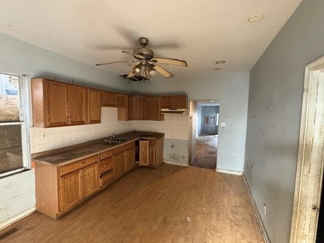 8370 S Baker Ave, Chicago, IL 60617 - kitchen with wood finished floors, under cabinet range hood, a sink, a ceiling fan, and brown cabinetry
