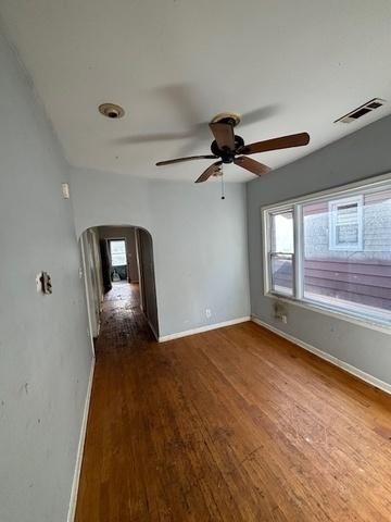 8370 S Baker Ave, Chicago, IL 60617 - empty room featuring arched walkways, ceiling fan, baseboards, and wood finished floors
