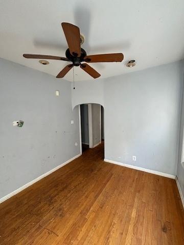 8370 S Baker Ave, Chicago, IL 60617 - spare room featuring a ceiling fan, arched walkways, wood finished floors, and baseboards