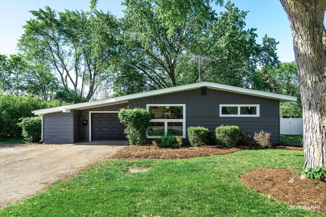 304 John St, North Aurora, IL 60542 - mid-century inspired home with driveway, a front lawn, and an attached garage