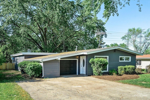 304 John St, North Aurora, IL 60542 - mid-century modern home featuring a garage, driveway, and fence