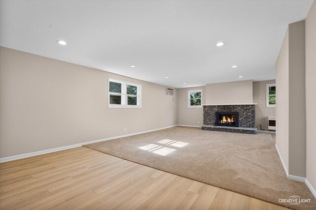 304 John St, North Aurora, IL 60542 - unfurnished living room featuring wood finished floors, baseboards, a fireplace, recessed lighting, and heating unit