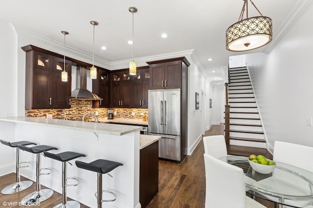3737 N Clifton Ave Unit 3, Chicago, IL 60613 - kitchen featuring high end refrigerator, wall chimney exhaust hood, glass insert cabinets, dark wood-type flooring, and recessed lighting