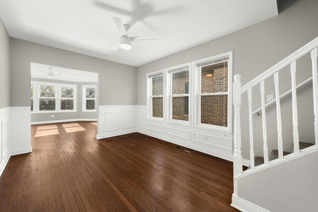 9028 S Ada St, Chicago, IL 60620 - unfurnished living room featuring a ceiling fan, dark wood-type flooring, a wainscoted wall, stairs, and a decorative wall