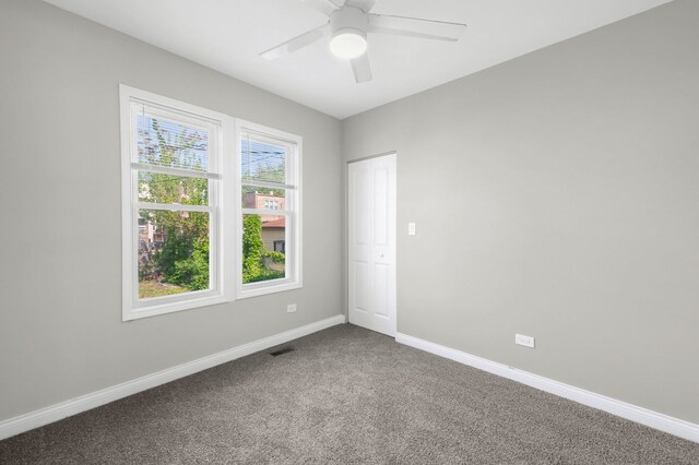 9028 S Ada St, Chicago, IL 60620 - empty room with dark colored carpet, baseboards, and a ceiling fan