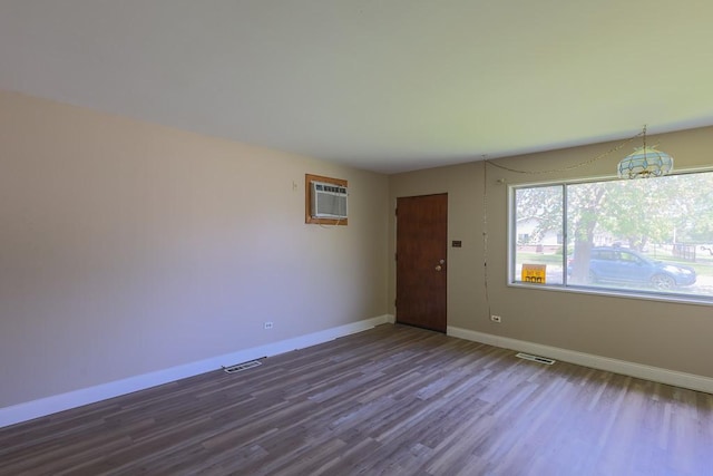 885 163rd St, Calumet City, IL 60409 - unfurnished room featuring dark wood-style floors, baseboards, an AC wall unit, and a chandelier
