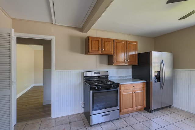 885 163rd St, Calumet City, IL 60409 - kitchen featuring appliances with stainless steel finishes, a ceiling fan, brown cabinets, light countertops, and wainscoting