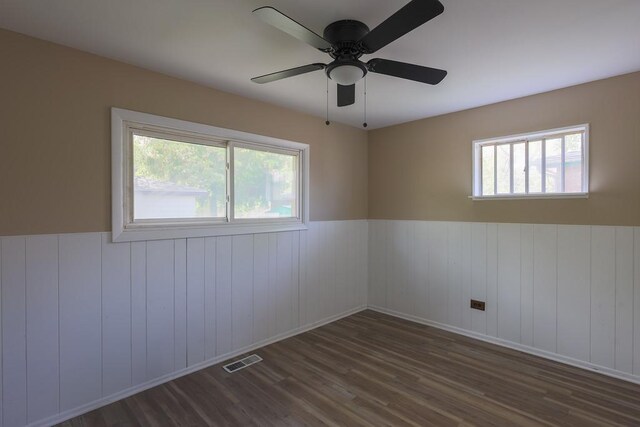 885 163rd St, Calumet City, IL 60409 - empty room with wood finished floors, a wainscoted wall, and a ceiling fan